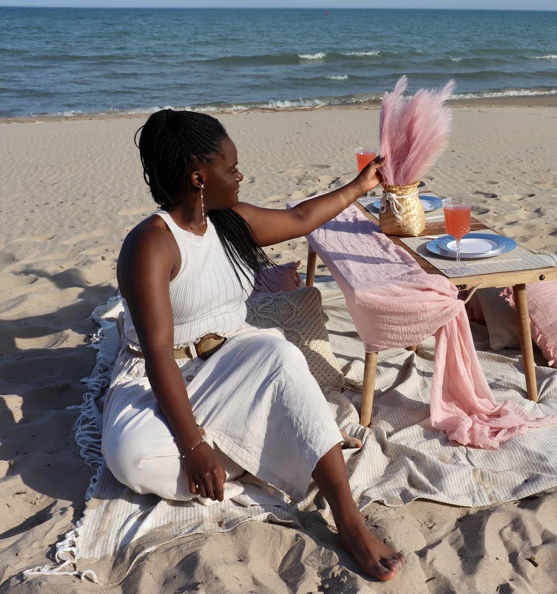 Talissa, founder of Picnics At The Bend, at a styled picnic on the beach in Grand Bend