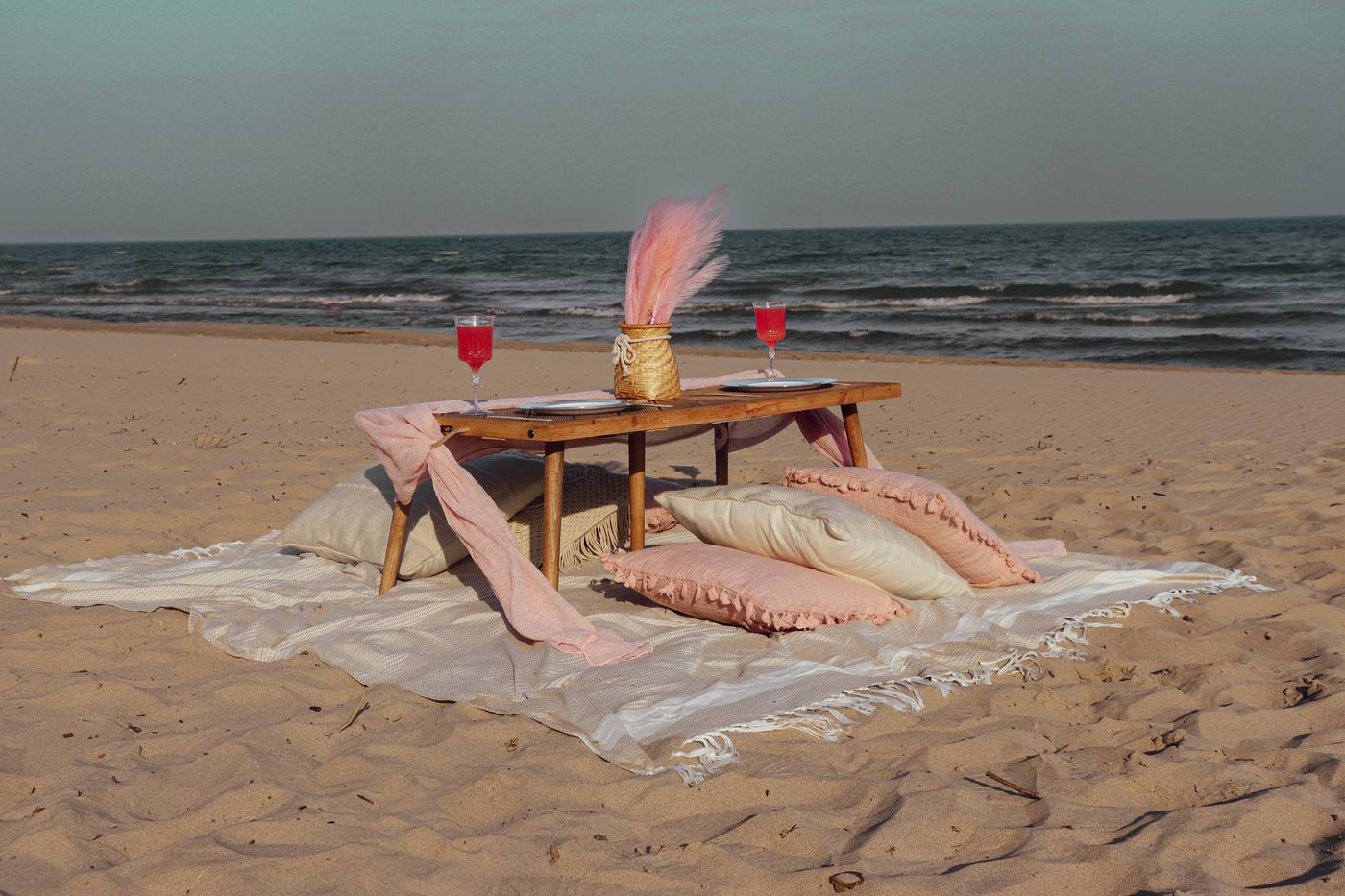 The Rosalie picnic kit — blush runner, pink pampas and soft cushions at golden hour